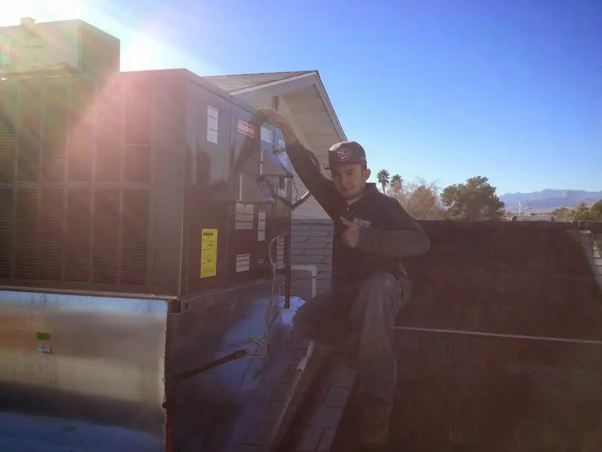 HVAC technician performing HVAC Inspection on a rooftop unit in Sheridan
